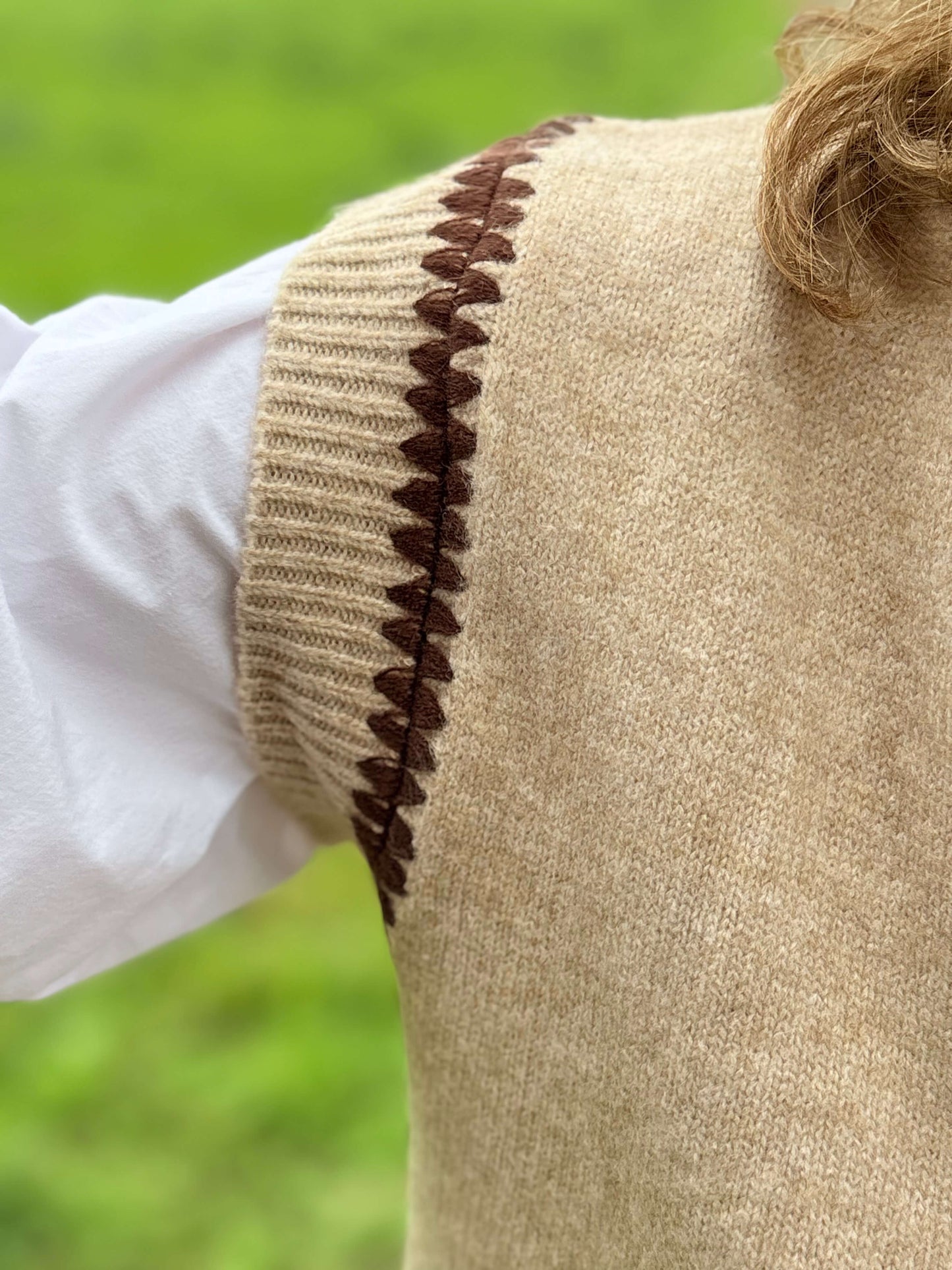 Détails pull beige femme col V avec liseré marron