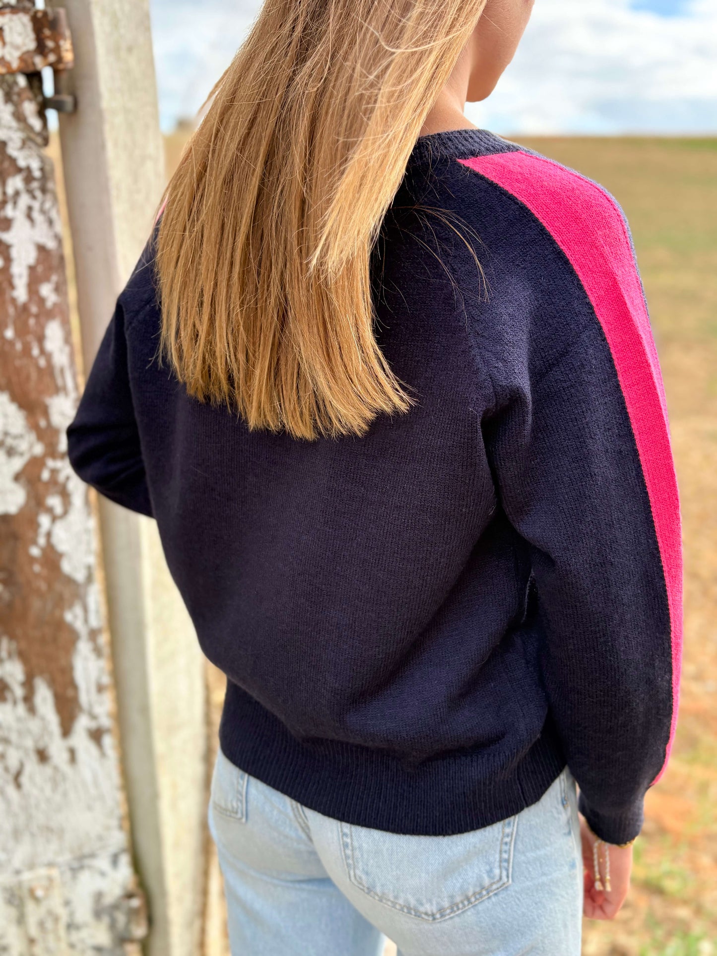 Dos pull femme bleu marine avec bande rose sur la manche
