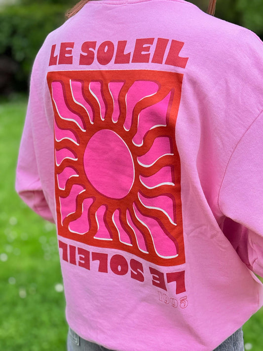 Dos du sweat rose oversize avec design graphique soleil
