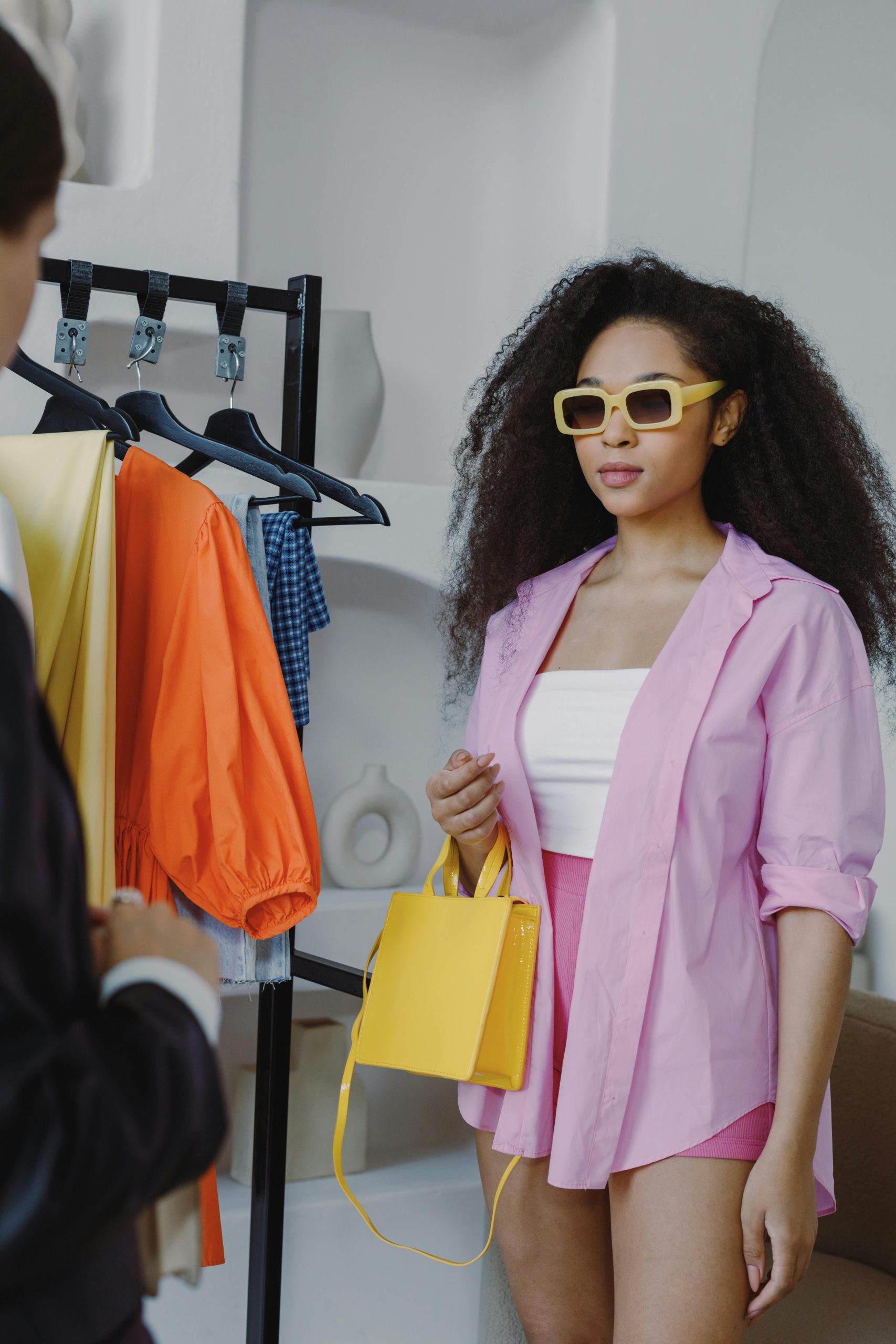 Woman en tenue vibrante faisant du shopping dans une boutique avec des vêtements colorés en exposition. Femme en tenue vibrante faisant du shopping dans une boutique avec des vêtements colorés exposés.