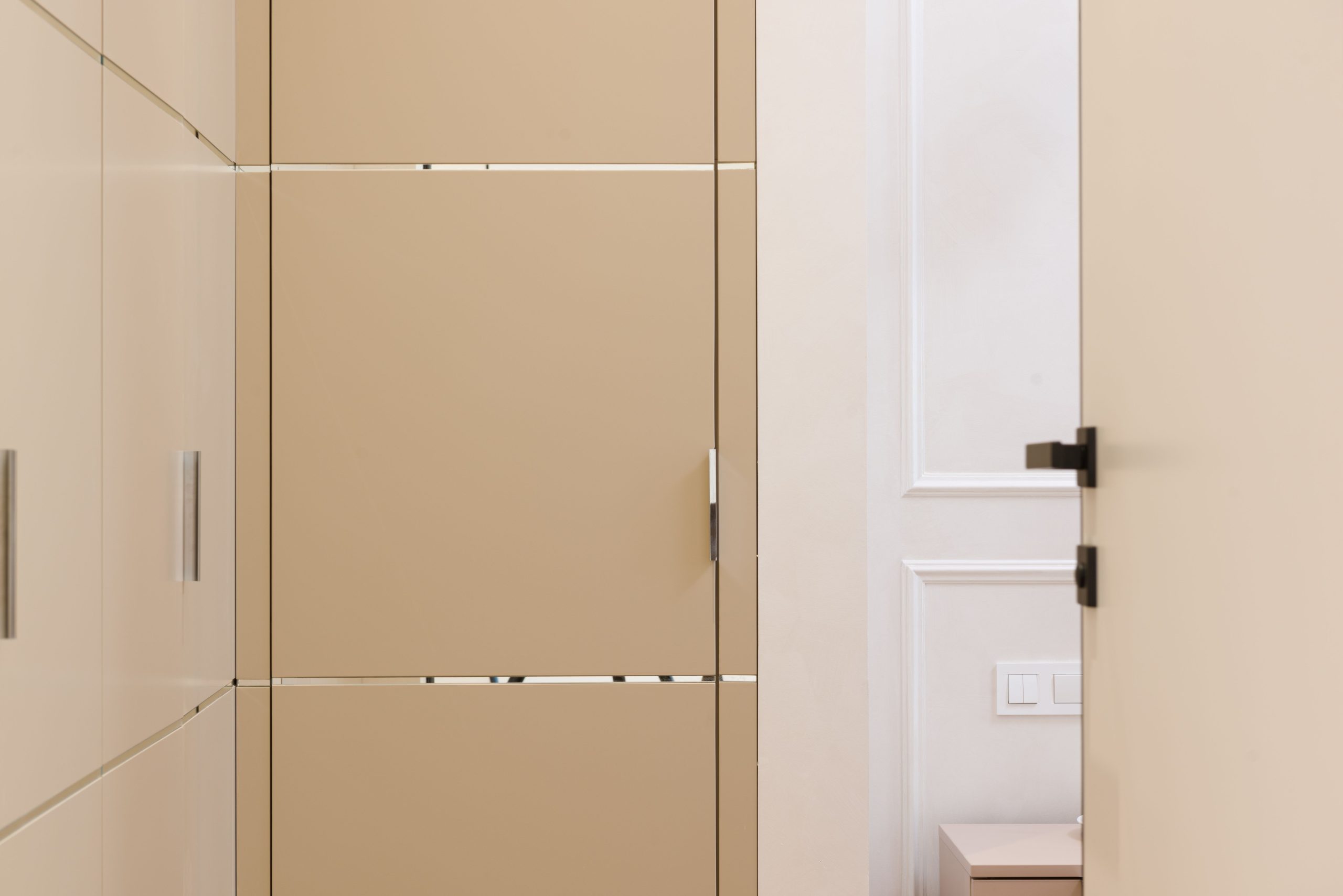 Portes de couleur beige et armoire dans le couloir d'un appartement contemporain au design minimaliste