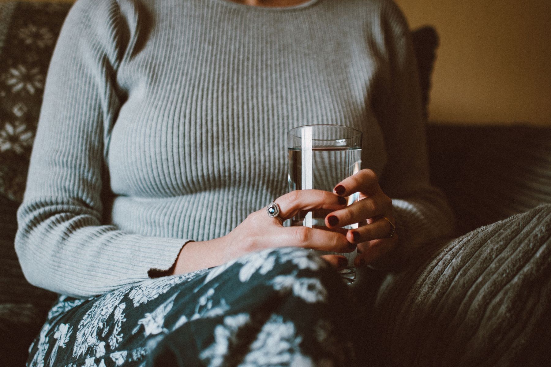 Femme assise tenant un verre d'eau, détendue