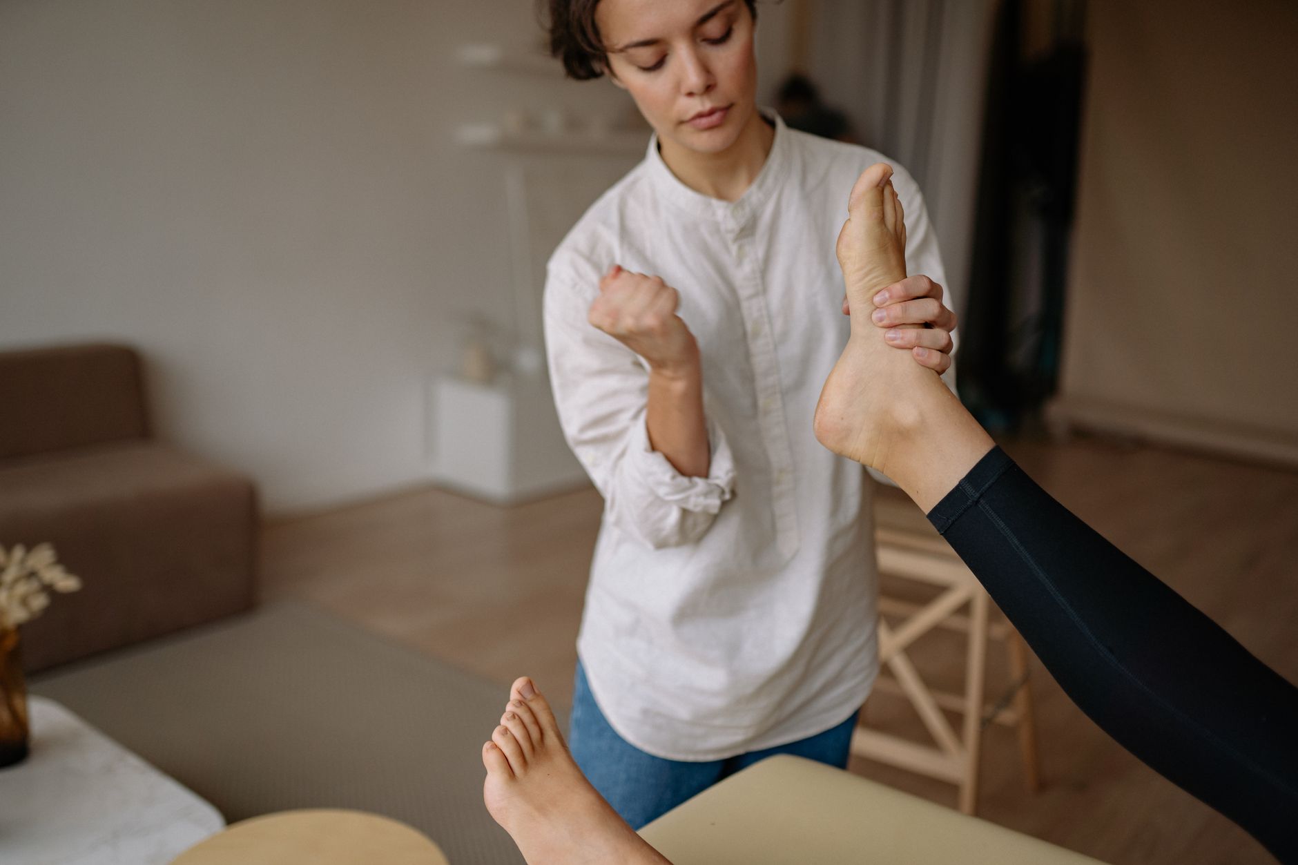 Femme se massant le dessus du pied pour soulager une douleur
