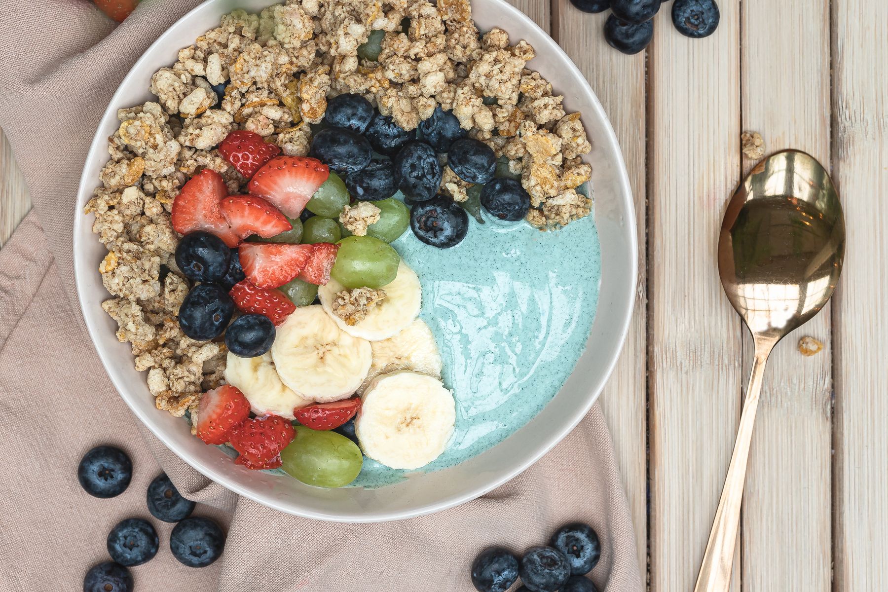 Bowl de smoothie bleu-vert garni de fruits frais