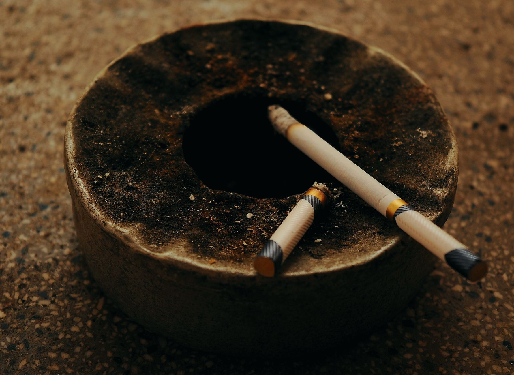 Cendrier ancien avec deux cigarettes consumées