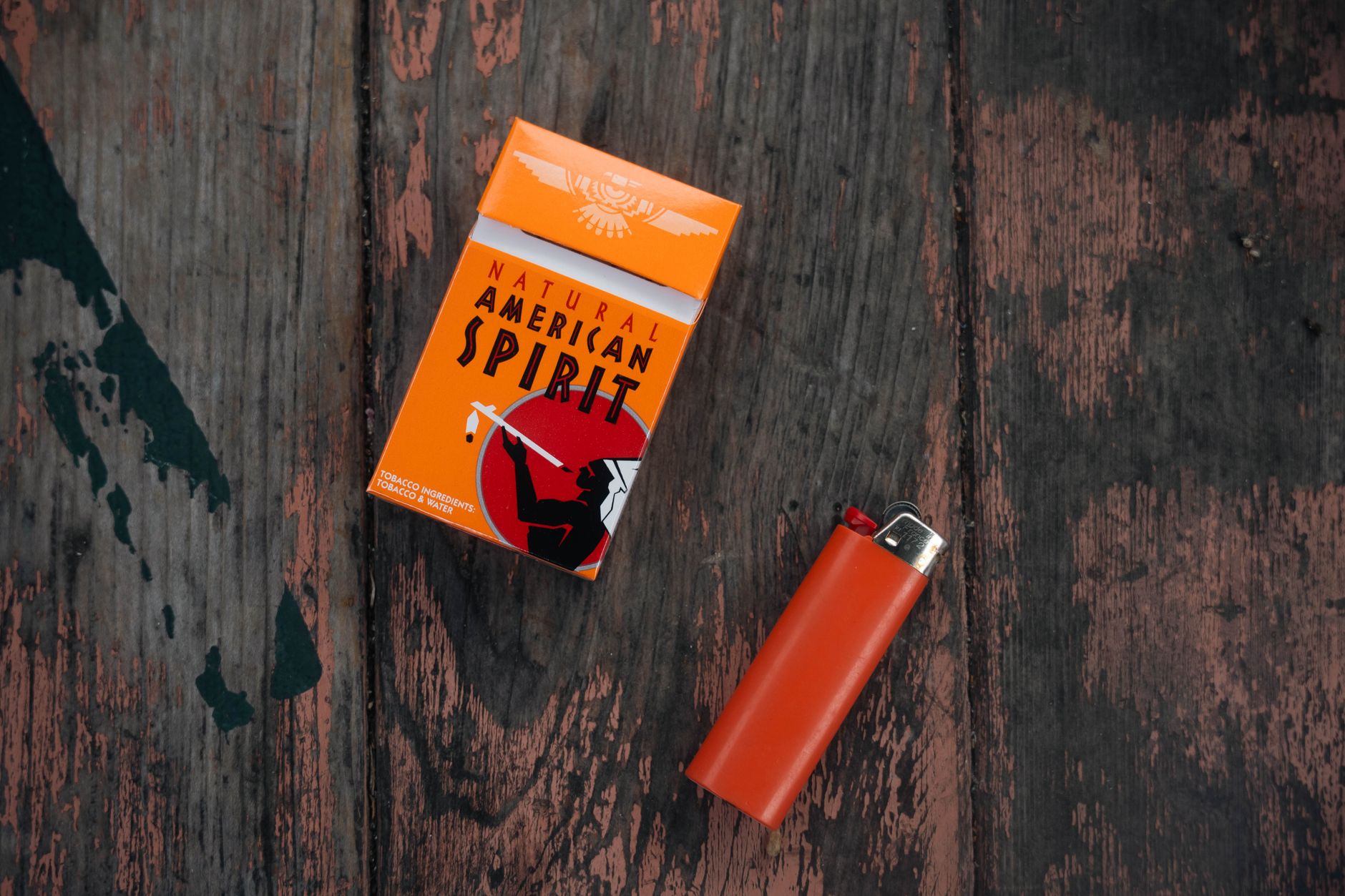 Paquet de cigarettes et briquet sur bois