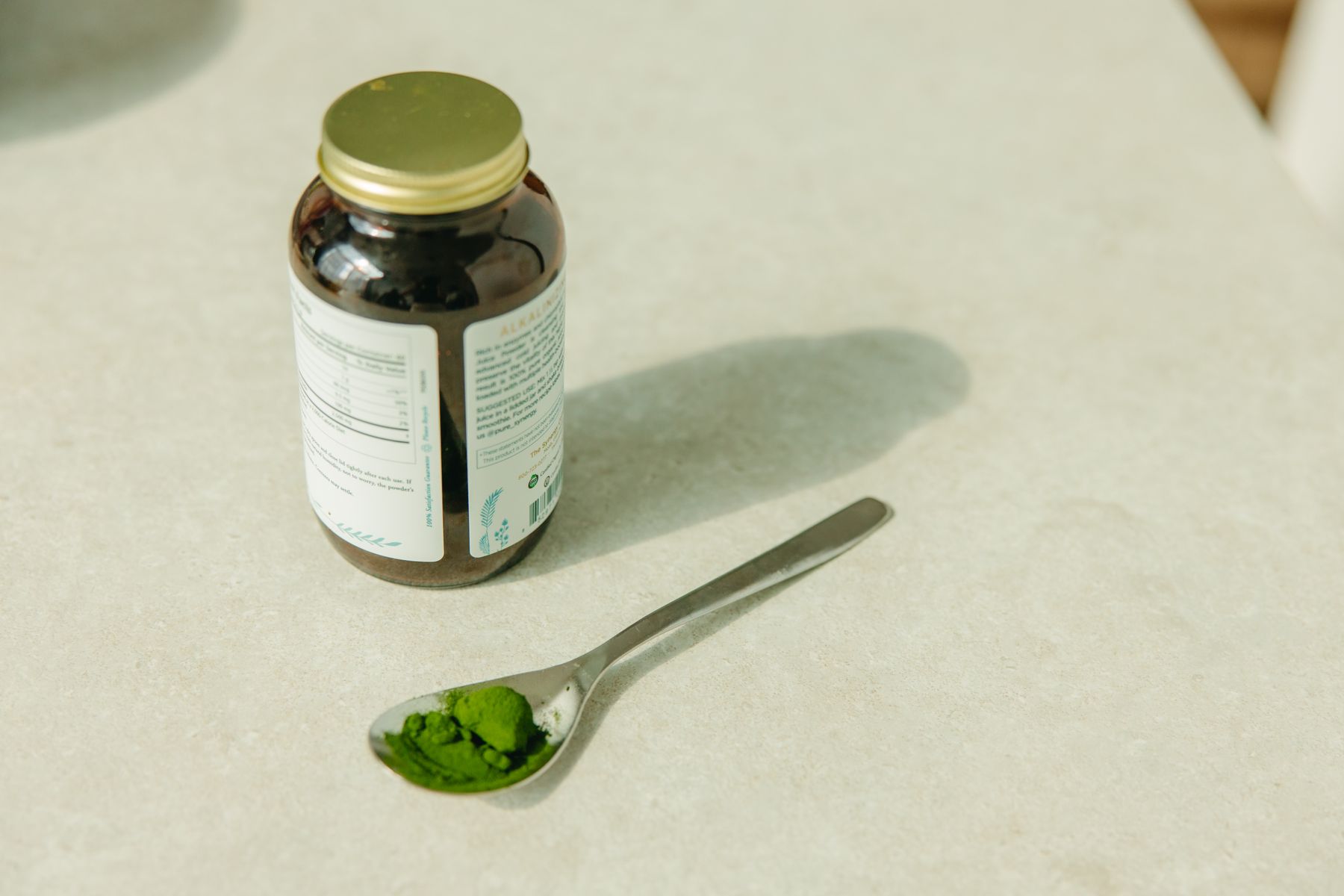 Cuillère de spiruline en poudre près d’un pilulier