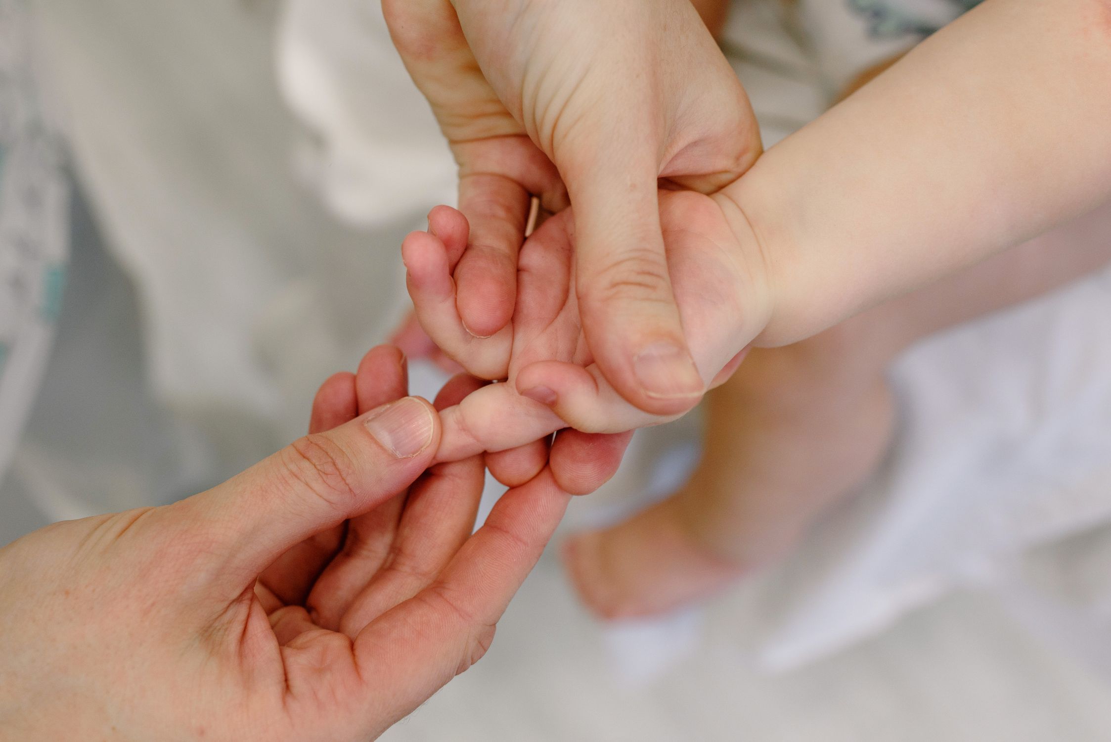 Massage délicat de la main d’un bébé par un adulte