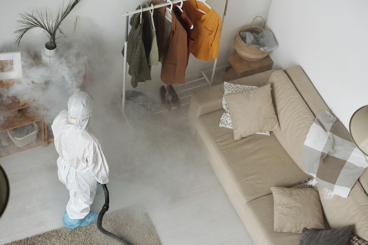 Professionnel en tenue de protection dans un logement