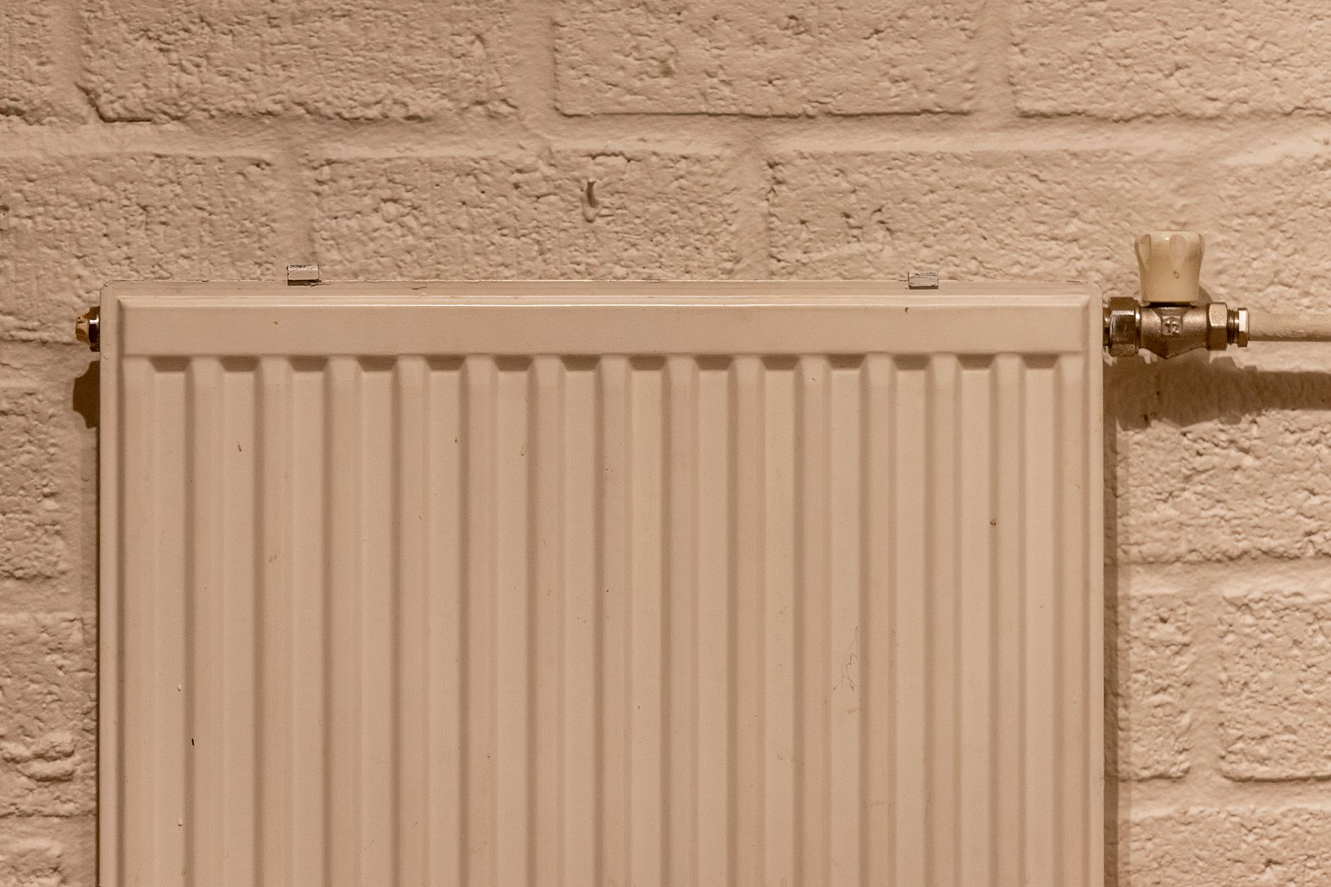 Radiateur blanc sur mur en brique